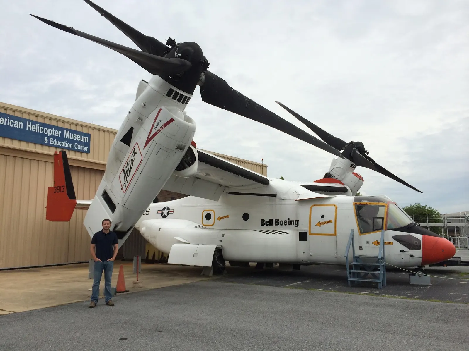Dan Garrick standing beside a Bell Boeing V-22 Osprey tiltrotor at the American Helicopter Museum